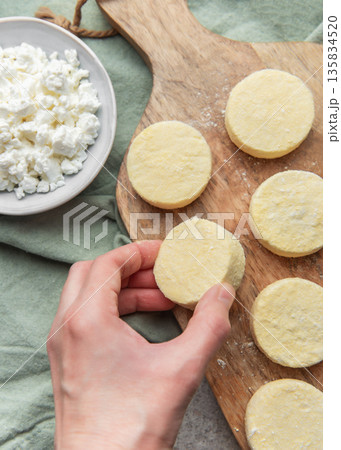 Preparing syrniki cottage cheese pancakes on cutting board 135834520