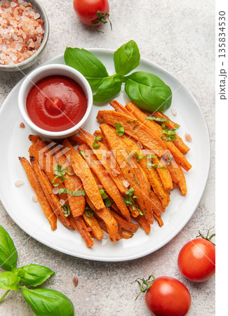 Sweet potato fries with ketchup and fresh basil 135834530