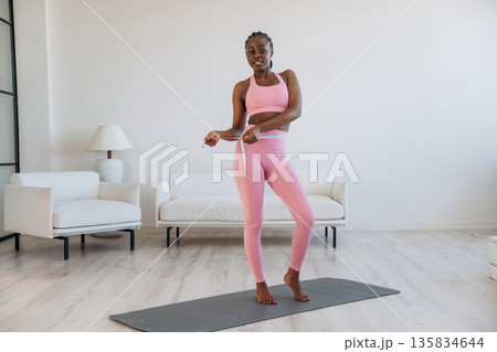 Diet conception, measuring the waist. Woman is doing yoga at home 135834644
