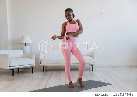 Diet conception, measuring the waist. Woman is doing yoga at home Diet conception, measuring the waist. Woman is doing yoga at home 135834645