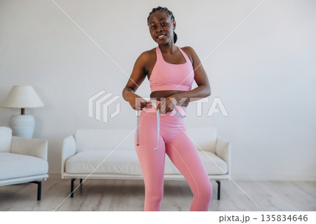 Diet conception, measuring the waist. Woman is doing yoga at home 135834646