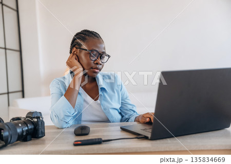 Sitting by the laptop. Woman is at home in domestic room 135834669