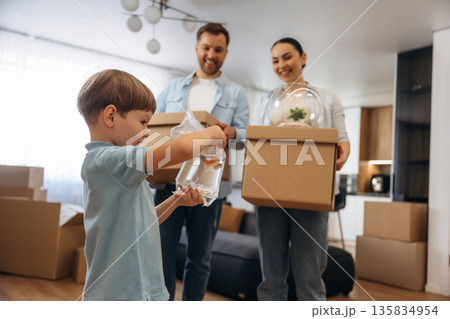 Boy is holding package with fish. Family of husband, wife and son are moving into new house Boy is holding package with fish. Family of husband, wife and son are moving into new house 135834954