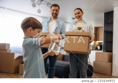 Boy is holding package with fish. Family of husband, wife and son are moving into new house Boy is holding package with fish. Family of husband, wife and son are moving into new house 135834955