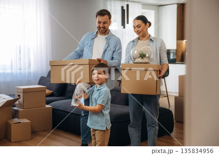 Boy is holding package with fish. Family of husband, wife and son are moving into new house Boy is holding package with fish. Family of husband, wife and son are moving into new house 135834956