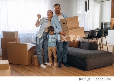 Joyful people, smiling. Family of husband, wife and son are moving into new house Joyful people, smiling. Family of husband, wife and son are moving into new house 135834968