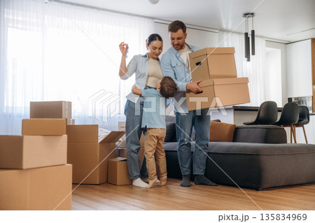 Joyful people, smiling. Family of husband, wife and son are moving into new house Joyful people, smiling. Family of husband, wife and son are moving into new house 135834969