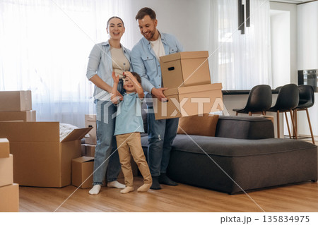 Kid is holding keys. Family of husband, wife and son are moving into new house 135834975
