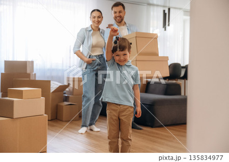 Kid is holding keys. Family of husband, wife and son are moving into new house 135834977