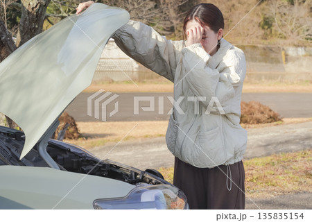 自動車のトラブルに困っている女性ドライバー 自動車のトラブルに困っている女性ドライバー 135835154