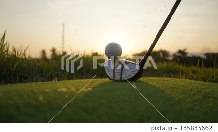 Golf clubs and balls on a green lawn in a beautiful golf course with morning sunshine. 135835662