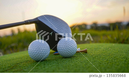 Golf club and golf balls on a green lawn in a beautiful golf course with morning sunshine. Golf club and golf balls on a green lawn in a beautiful golf course with morning sunshine. 135835668