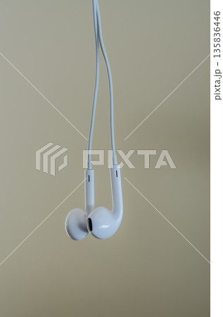Minimalist composition of classic white wired earbuds. 135836446