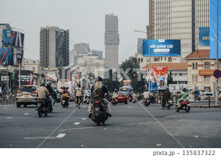 Busy city street with many motorcycles and cars 135837322