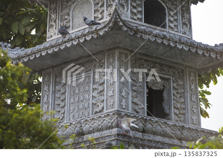 Gray building with a birdhouse on top 135837325