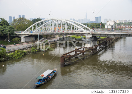 Boat is floating on a river near a bridge Boat is floating on a river near a bridge 135837329