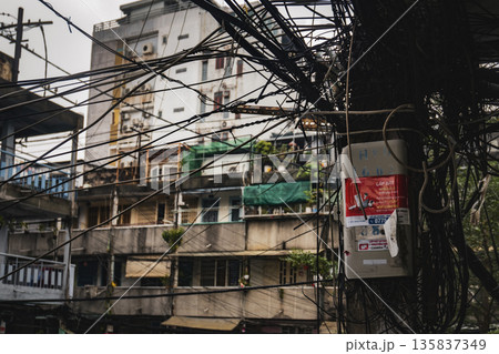 Cityscape with a lot of wires and a red sign on a pole 135837349