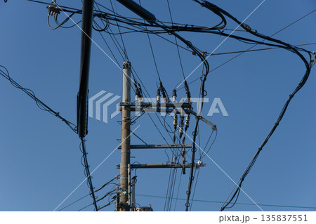複雑に入り組んだ電線と電柱 135837551