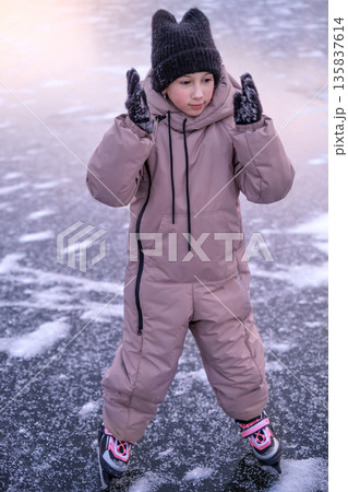 Child practicing ice skating skills on a frozen lake, learning balance, coordination and confidence during winter outdoor training Child practicing ice skating skills on a frozen lake, learning balance, coordination and confidence during winter outdoor training 135837614