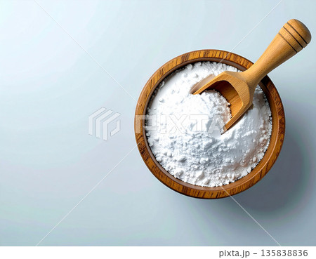 Nontoxic cleaning. Pile of powdered detergent in a wooden bowl with a wooden spoon on a white background. Baking soda. Nontoxic cleaning. Pile of powdered detergent in a wooden bowl with a wooden spoon on a white background. Baking soda. 135838836