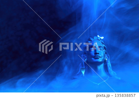 Maha Shivratri background. Adiyogi shiva statue meditating in blue mystical smoke Maha Shivratri background. Adiyogi shiva statue meditating in blue mystical smoke 135838857