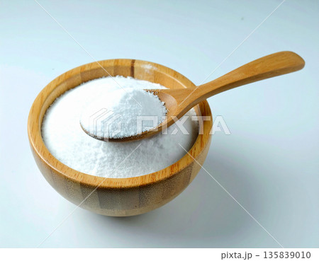 Home eco cleaning. Pile of powdered detergent in a wooden bowl with a wooden spoon on a white background. Baking soda. Home eco cleaning. Pile of powdered detergent in a wooden bowl with a wooden spoon on a white background. Baking soda. 135839010