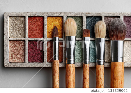 Perfect for beauty product launches. Flat lay of makeup brush placed next to a color palette on white background. Perfect for beauty product launches. Flat lay of makeup brush placed next to a color palette on white background. 135839062