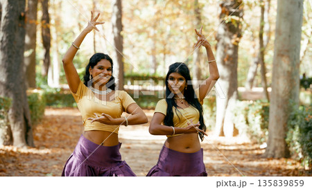 Indian women performing traditional indian dance outdoors Indian women performing traditional indian dance outdoors 135839859