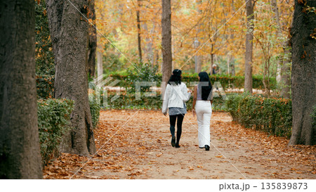 Indian women walking and talking in autumn park 135839873