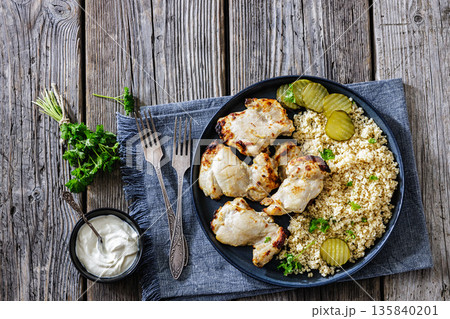 Boneless chicken thighs and couscous on a plate 135840201