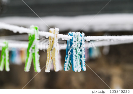 A line of clothespins are frozen in the snow 135840226
