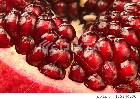 A close up of a pomegranate fruit with many small seeds A close up of a pomegranate fruit with many small seeds 135840230