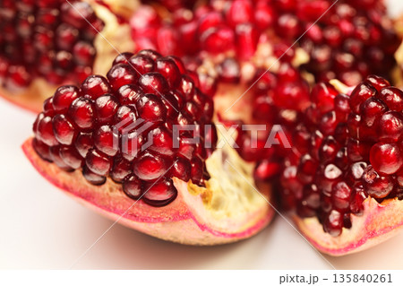 A close up of a red pomegranate fruit with a few seeds visible 135840261