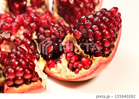 A close up of a red pomegranate fruit with a bite taken out of it A close up of a red pomegranate fruit with a bite taken out of it 135840262