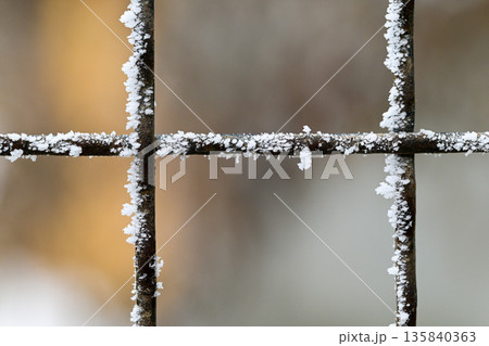 A metal fence covered in snow A metal fence covered in snow 135840363