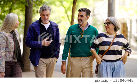 Group of senior friends walking and talking Group of senior friends walking and talking 135840449