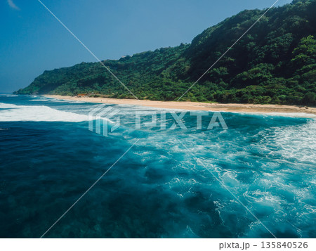 Drone view of beach coastline with green hills in Bali. Nyang Nyang beach Drone view of beach coastline with green hills in Bali. Nyang Nyang beach 135840526
