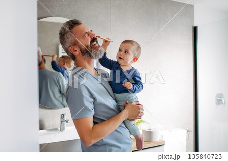 Little boy hitting his father in face. Little boy hitting his father in face. 135840723