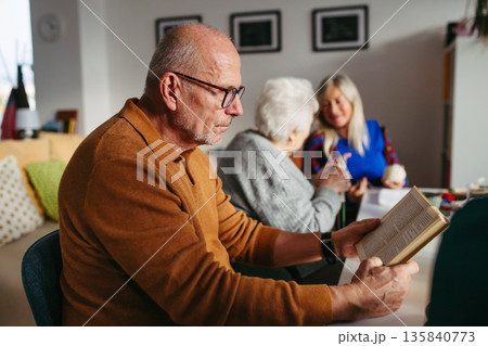 Group of senior people enjoying different activities in community center. 135840773