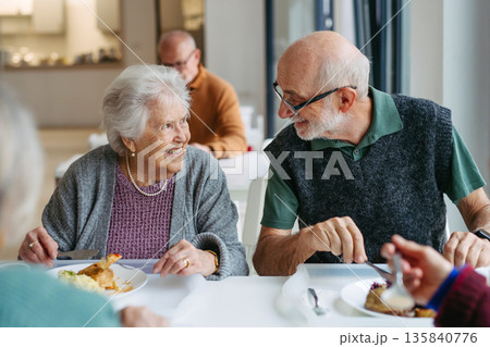 Elderly couple having lunch in community center cafeteria. 135840776