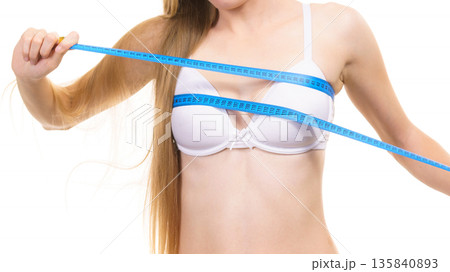 Girl measuring her chest breasts bust size 135840893