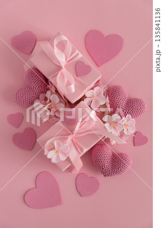 Gift Boxes, Knitted Hearts and Sakura Flowers. Romantic Valentines Day Flatlay on Pink Background 135841136