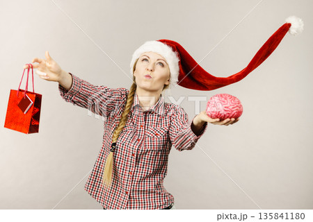Christmas woman holding shopping bag and brain Christmas woman holding shopping bag and brain 135841180
