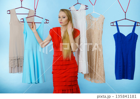 Woman choosing clothes in shop Woman choosing clothes in shop 135841181
