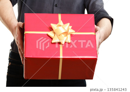 Holiday. Man giving red gift box with golden ribbon 135841243