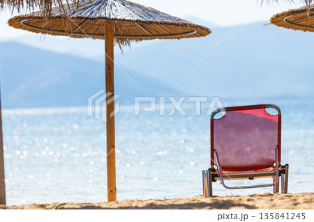 Sun parasols and deck chairs on beach 135841245