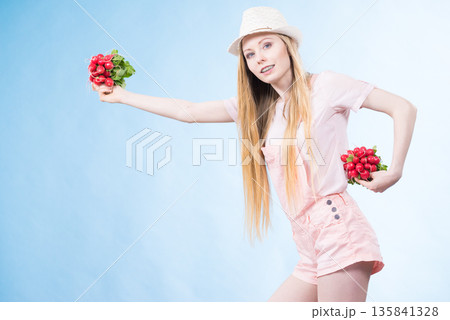 Young woman holding radish Young woman holding radish 135841328