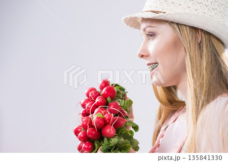 Young woman holding radish Young woman holding radish 135841330