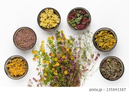 Dry medicinal herbs assortment on white background. Dry medicinal herbs assortment on white background. 135841387