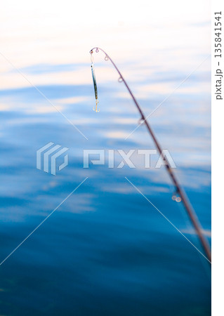 saltwater fishing - rod with wobbler and blue sea water 135841541